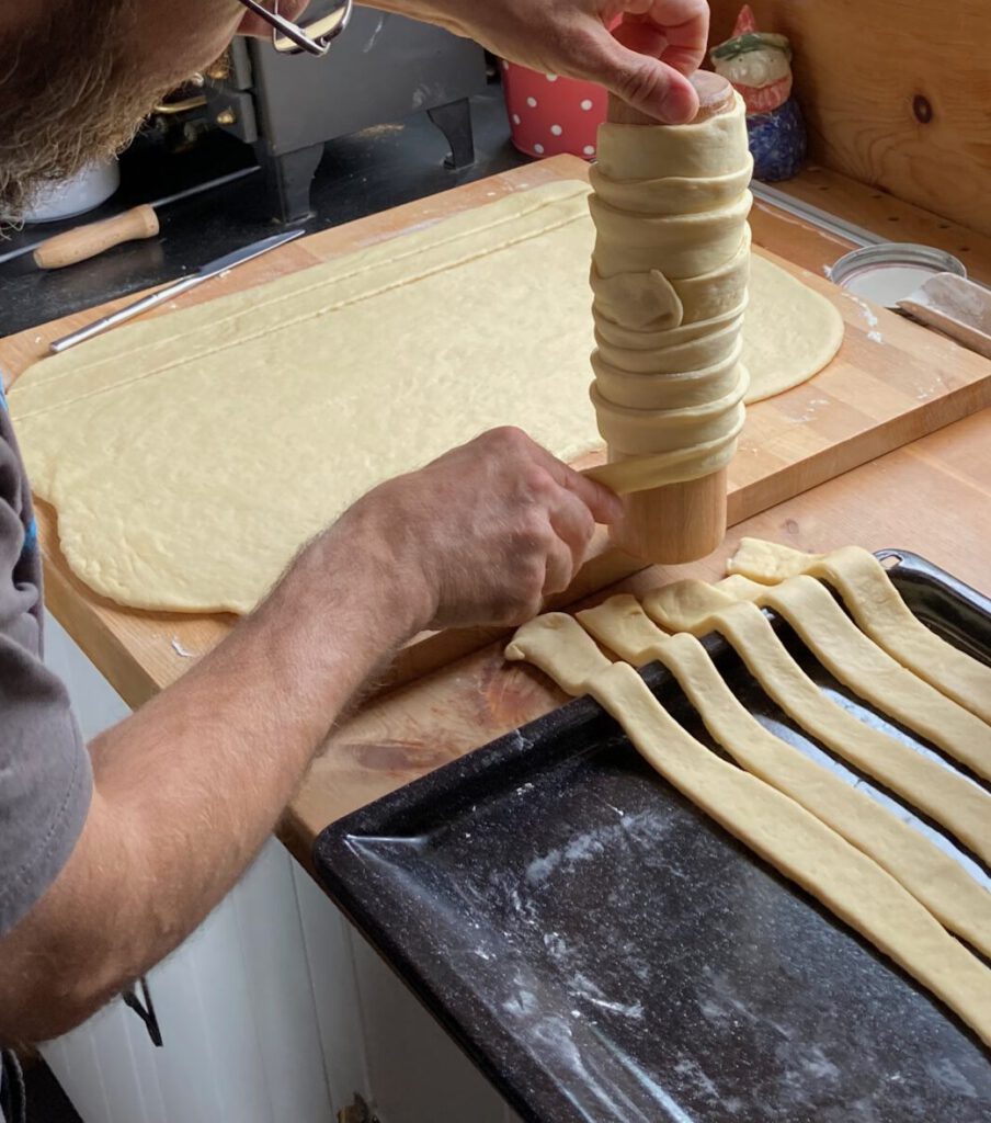Ausgerollter Hefeteig, Streifen und Rolle für Baumstriezel